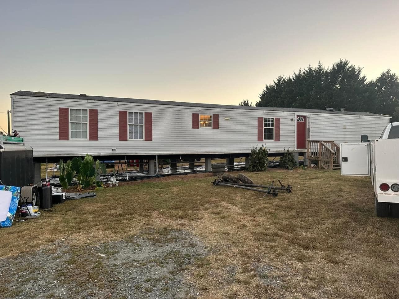 A mobile home is sitting in the middle of a grassy field.