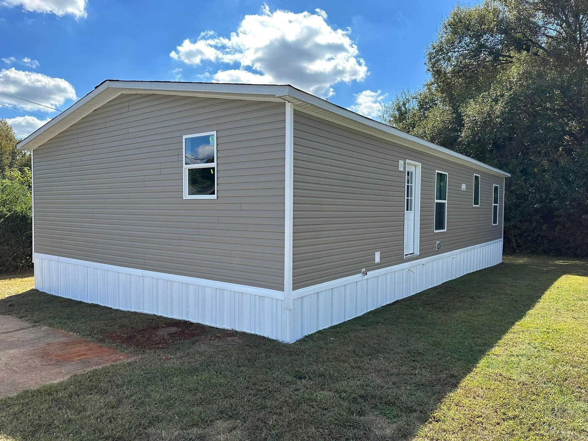 A mobile home is sitting on top of a lush green field.
