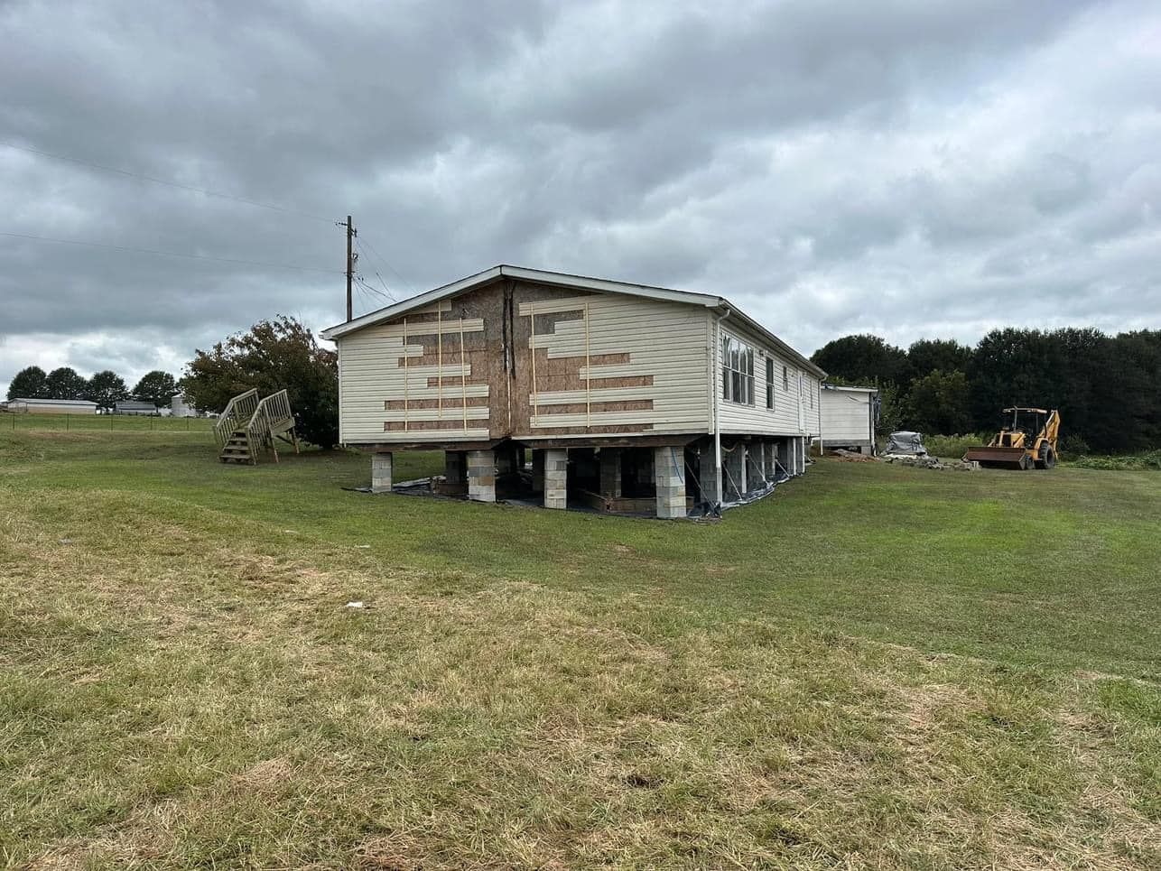 A mobile home is sitting in the middle of a grassy field.