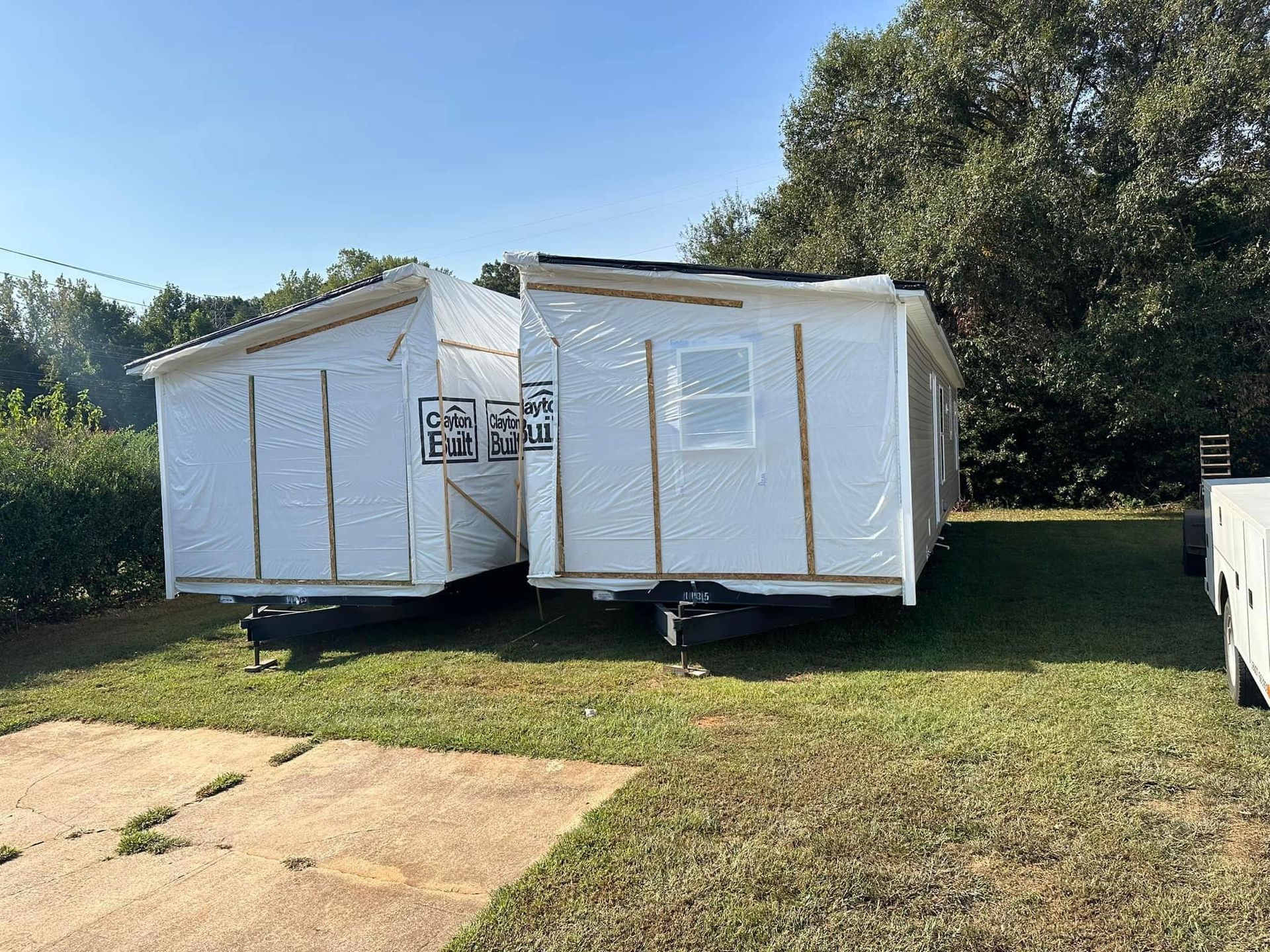 A small house is sitting on top of a lush green field.