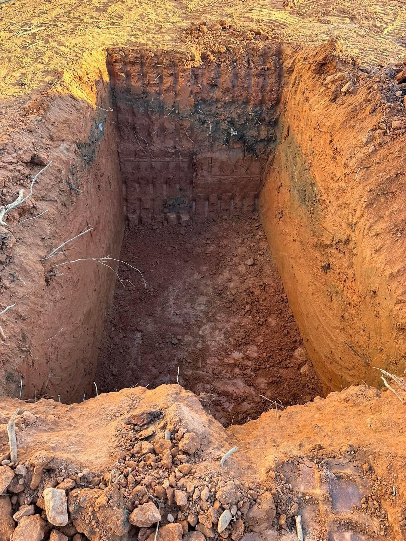 A large hole in the ground filled with dirt and rocks.