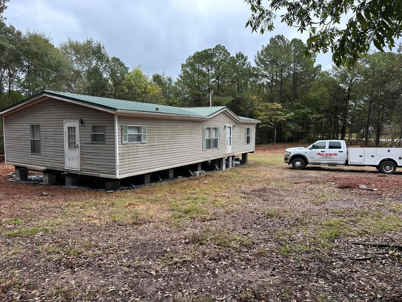 A white truck is parked in front of a mobile home.