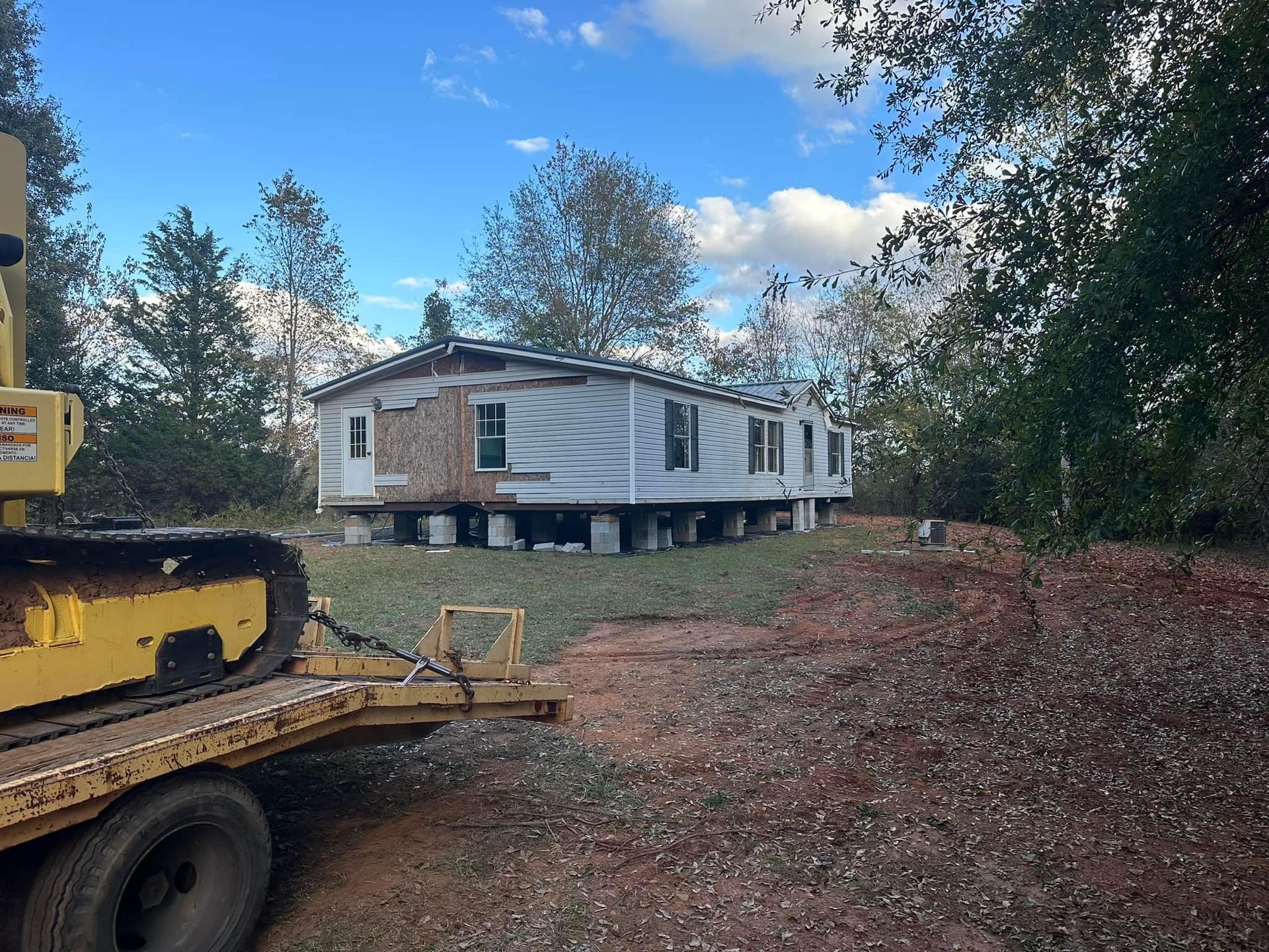 A yellow truck is towing a mobile home on a trailer
