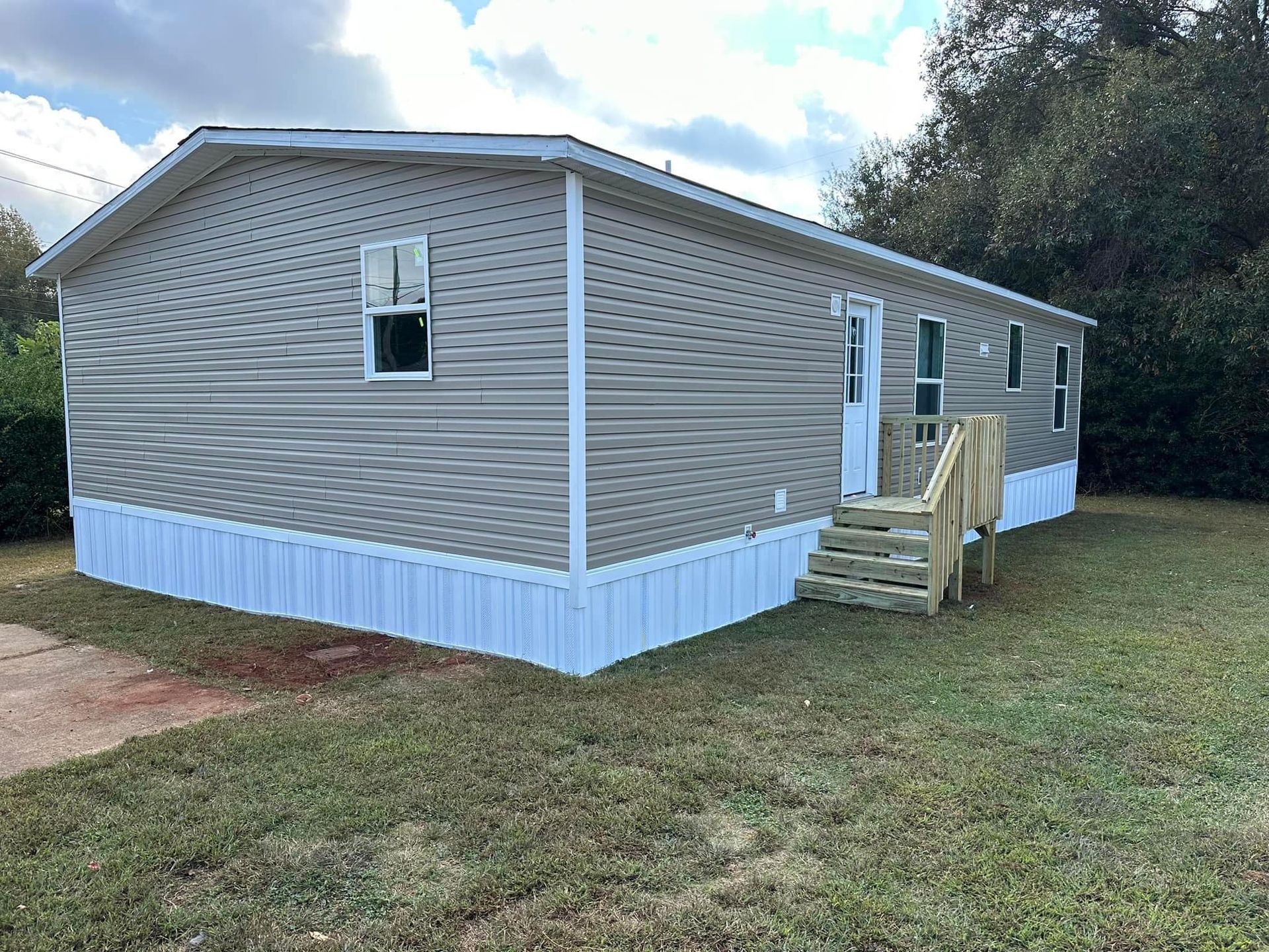 A mobile home is sitting on top of a lush green field.