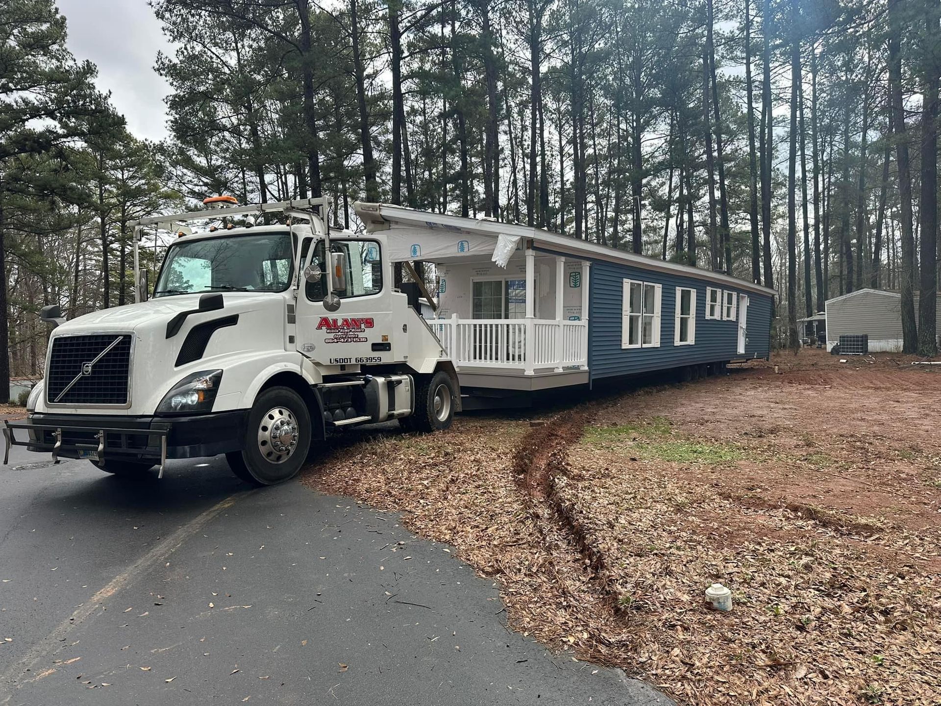 A tow truck is towing a mobile home down a road.