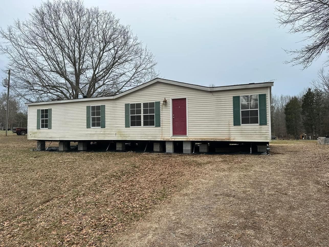 A mobile home is sitting in the middle of a field.