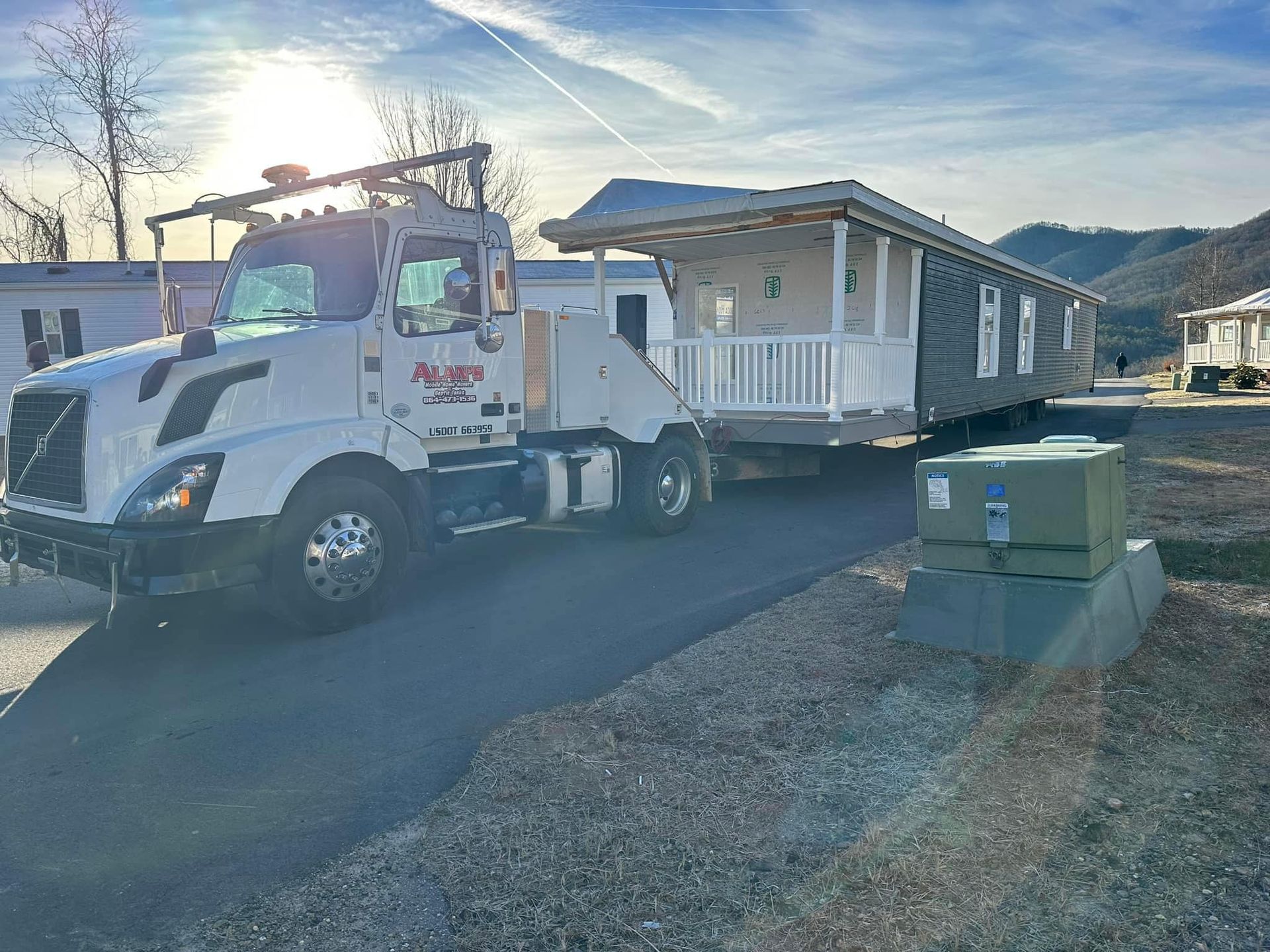 A tow truck is carrying a mobile home down a road.