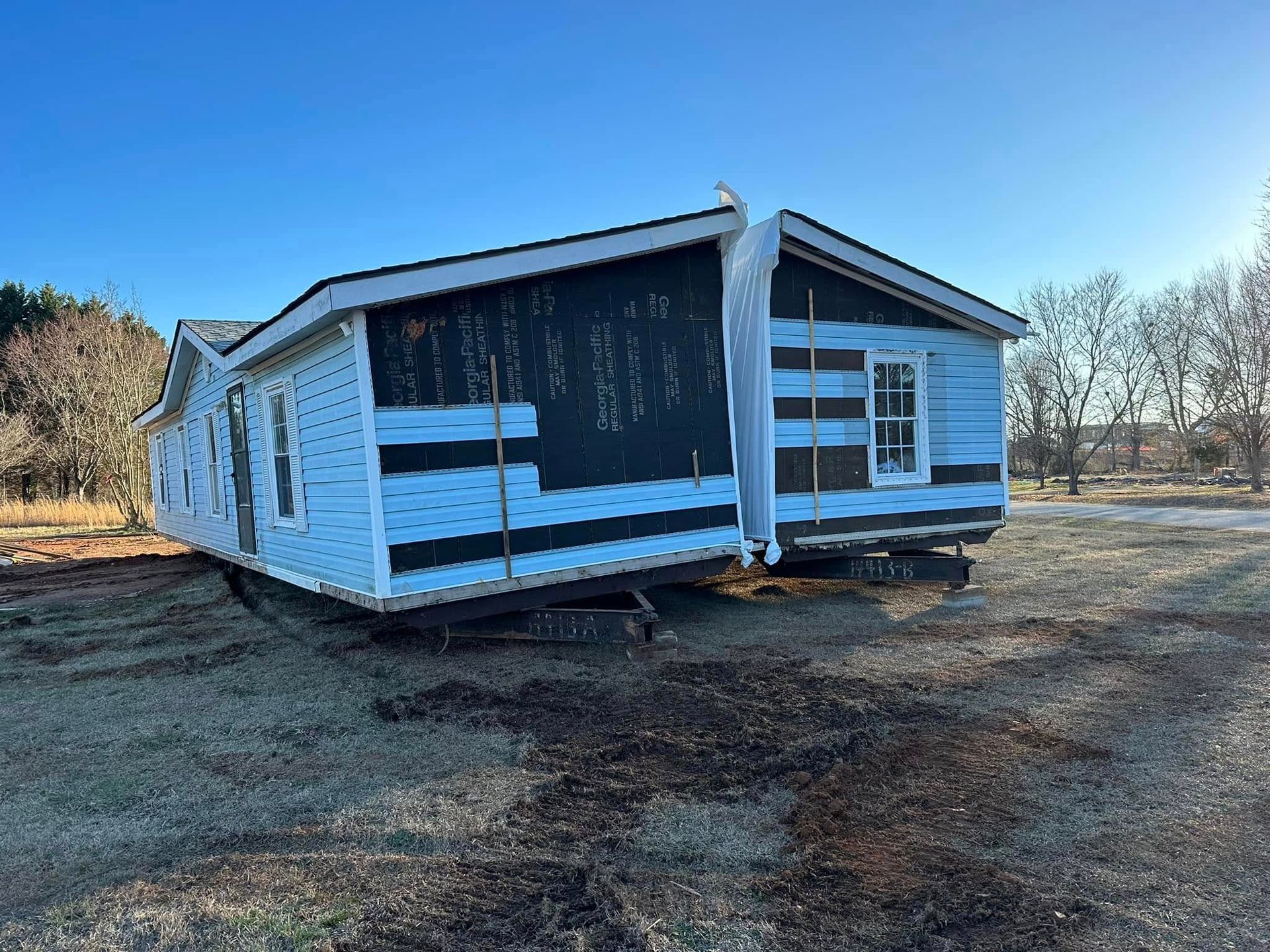 A mobile home is sitting in the middle of a field.