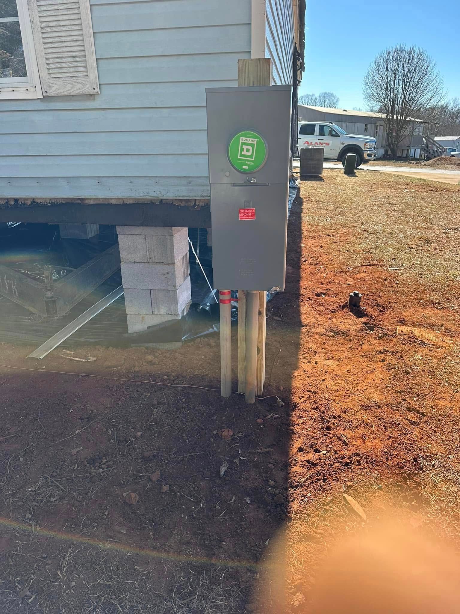 A black box is sitting on the side of a house.