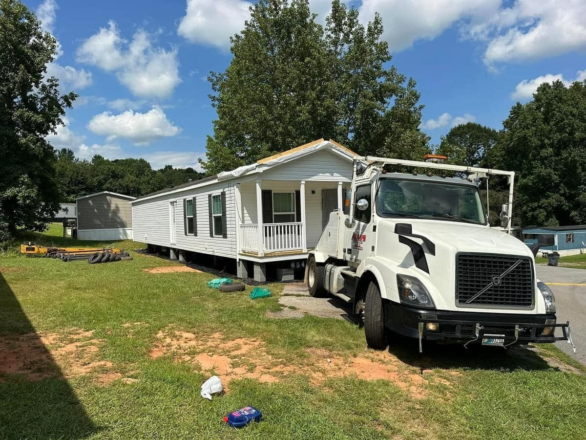 A white truck is parked in front of a mobile home.