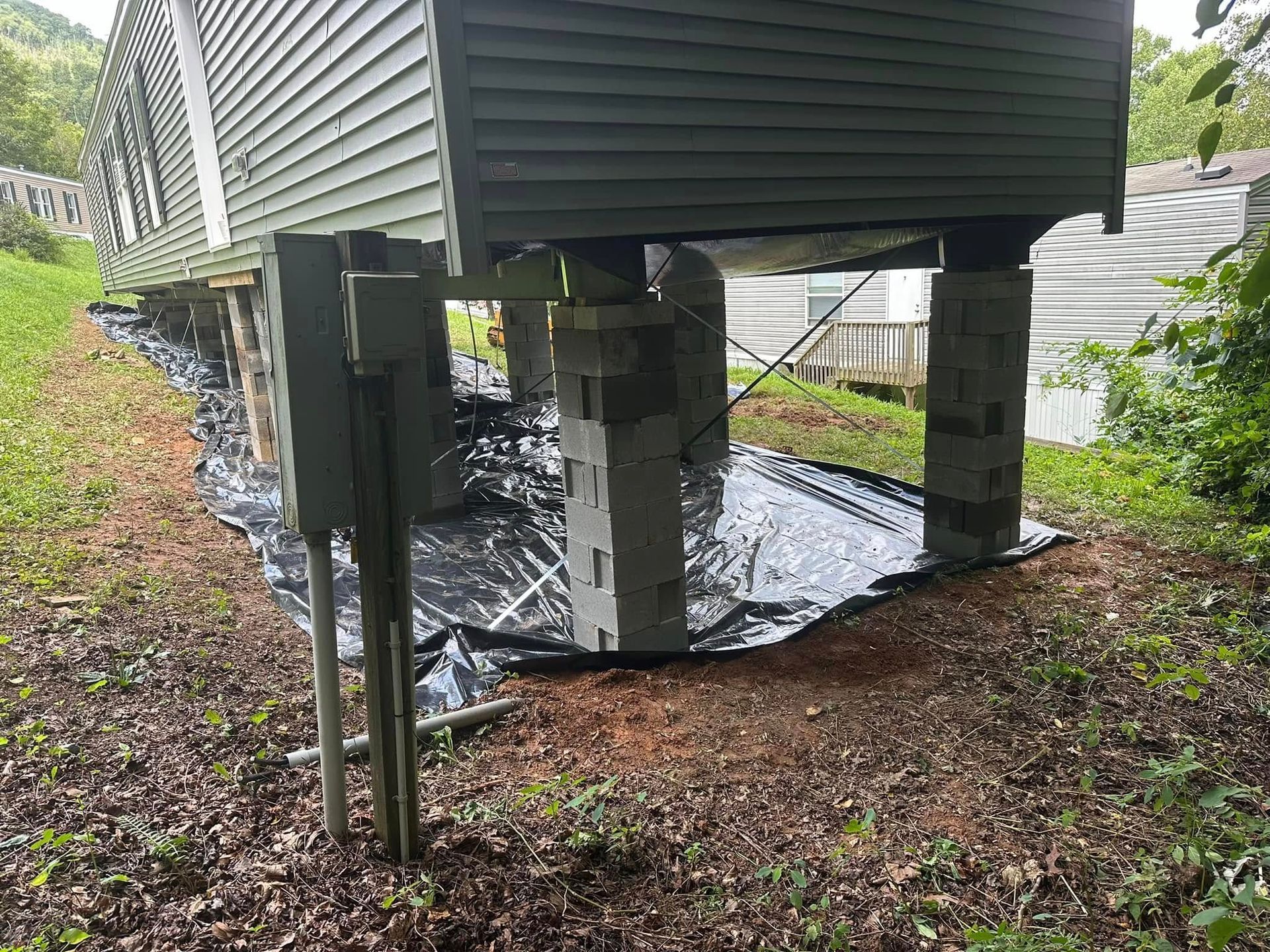 A small house is sitting on top of a pile of concrete blocks.