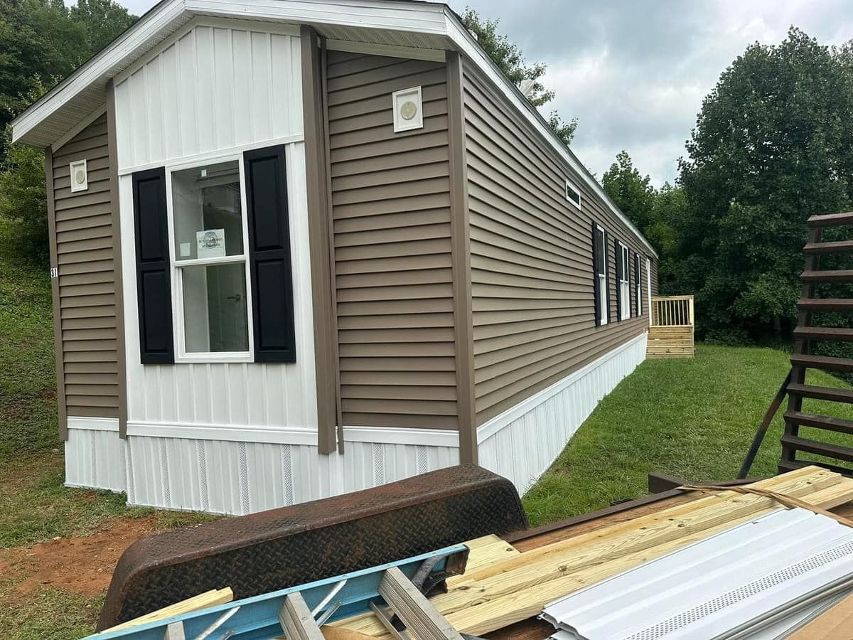 A mobile home with a ladder in front of it is being built.