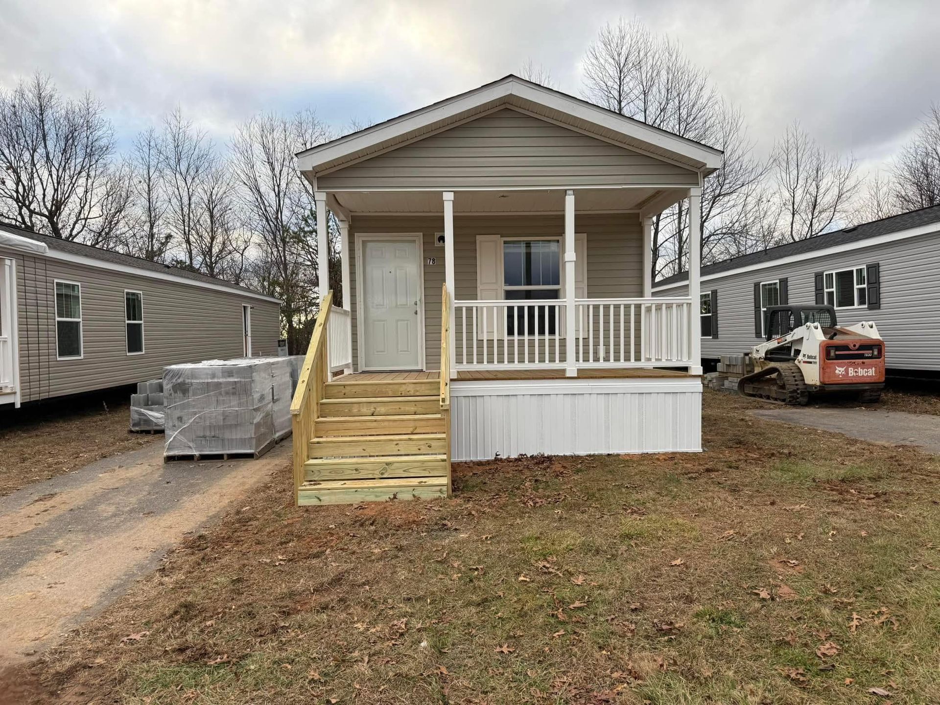 A mobile home with a porch and stairs is being built.