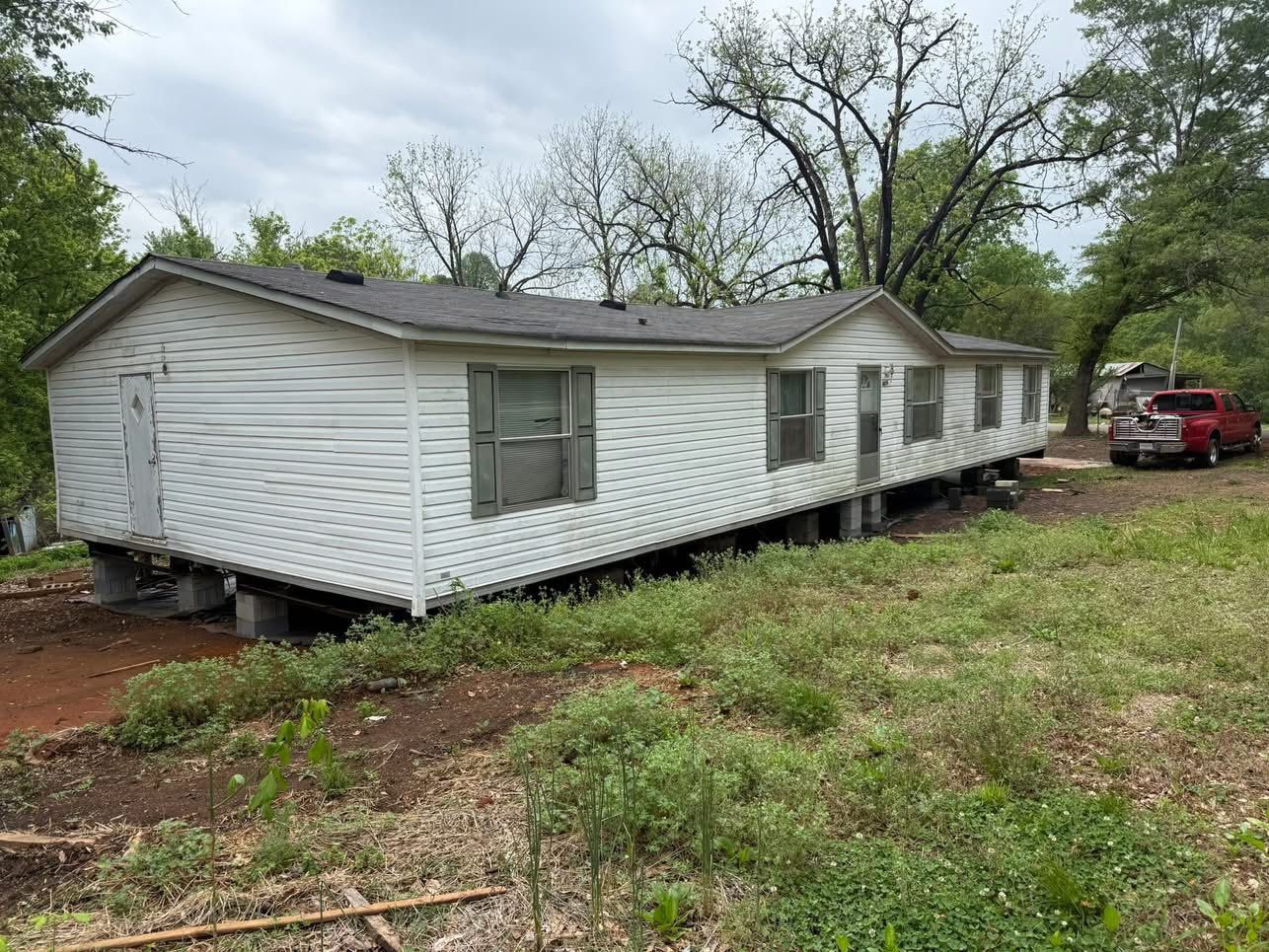 A mobile home is sitting in the middle of a grassy field. A mobile home is sitting in the middle of a grassy field.