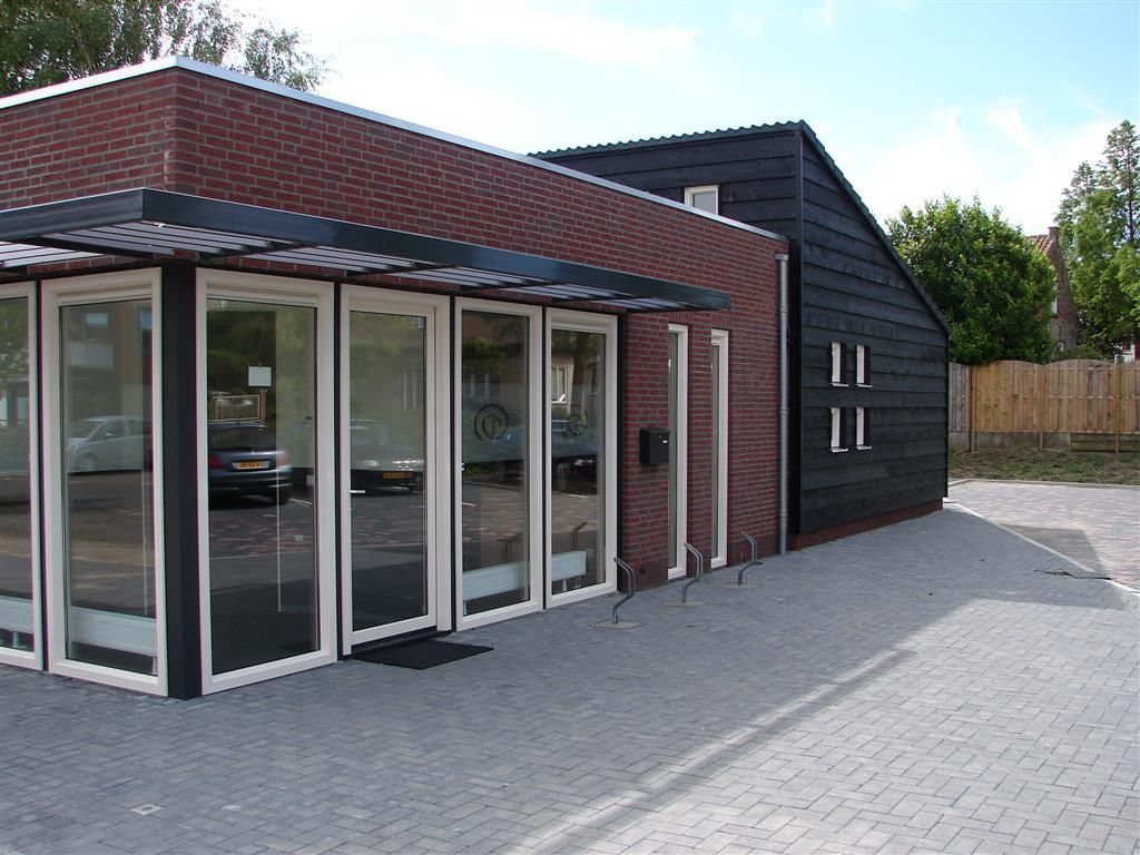 A brick building with a black roof and a lot of windows