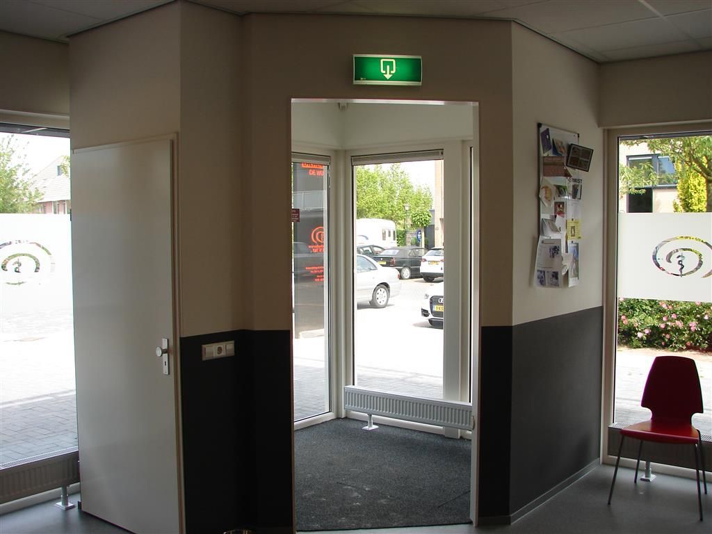 A green exit sign hangs above a doorway