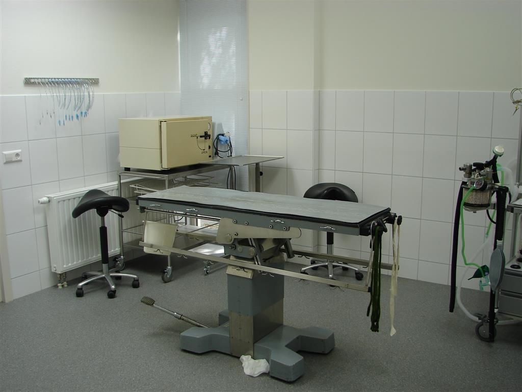 An empty operating room with a table and chairs
