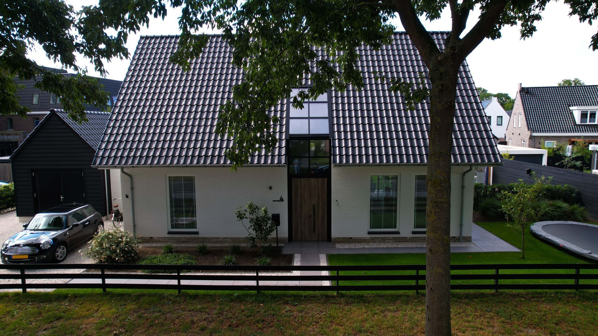 Moderne villa met landelijke invloeden. Deze stijlvolle vrijstaande woning combineert moderne architectuur met subtiele landelijke elementen. De strakke witte gevels in combinatie met het donkere zadeldak zorgen voor een eigentijdse en frisse uitstraling.