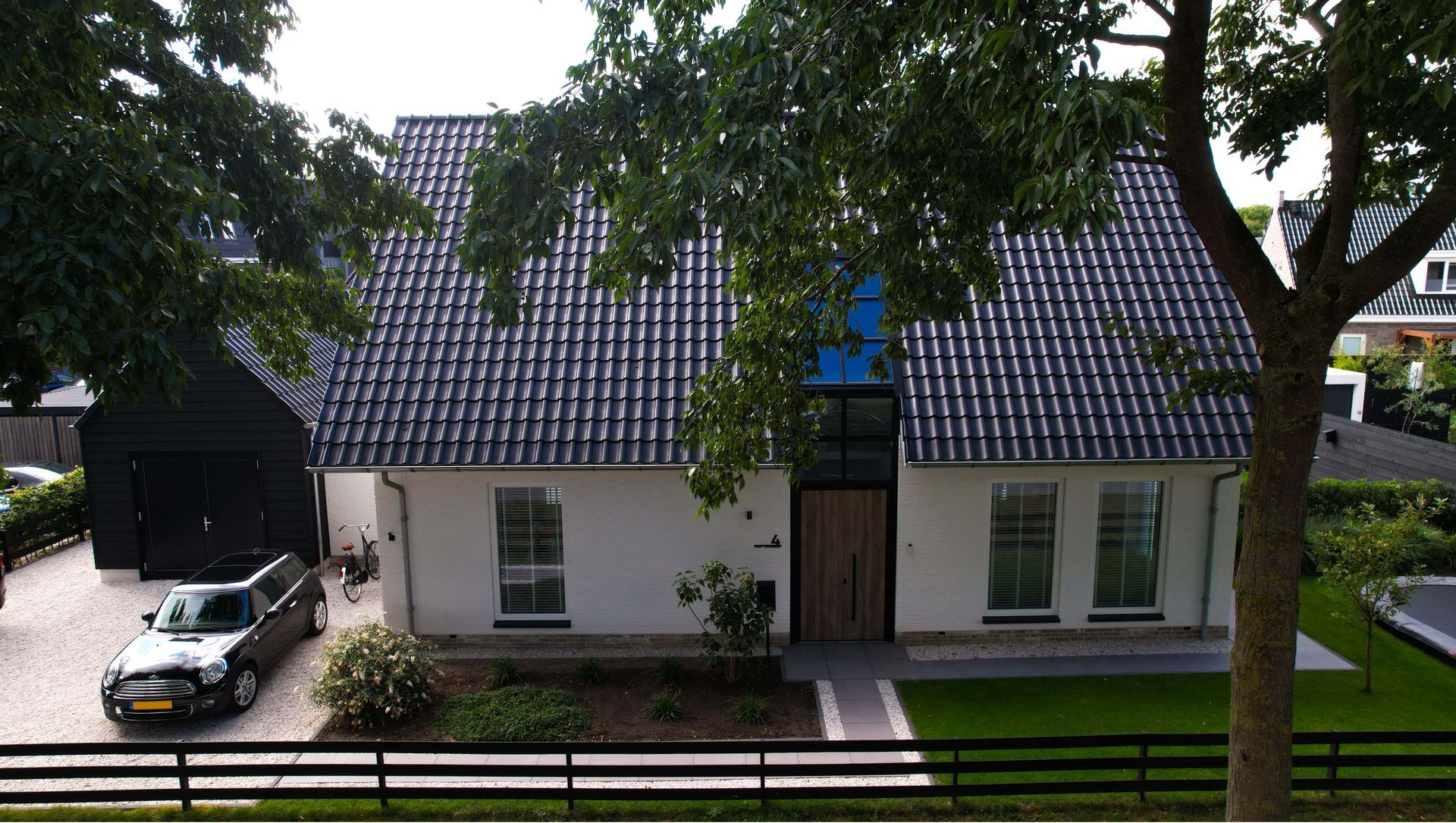 Moderne villa met landelijke invloeden. Deze stijlvolle vrijstaande woning combineert moderne architectuur met subtiele landelijke elementen. De strakke witte gevels in combinatie met het donkere zadeldak zorgen voor een eigentijdse en frisse uitstraling.