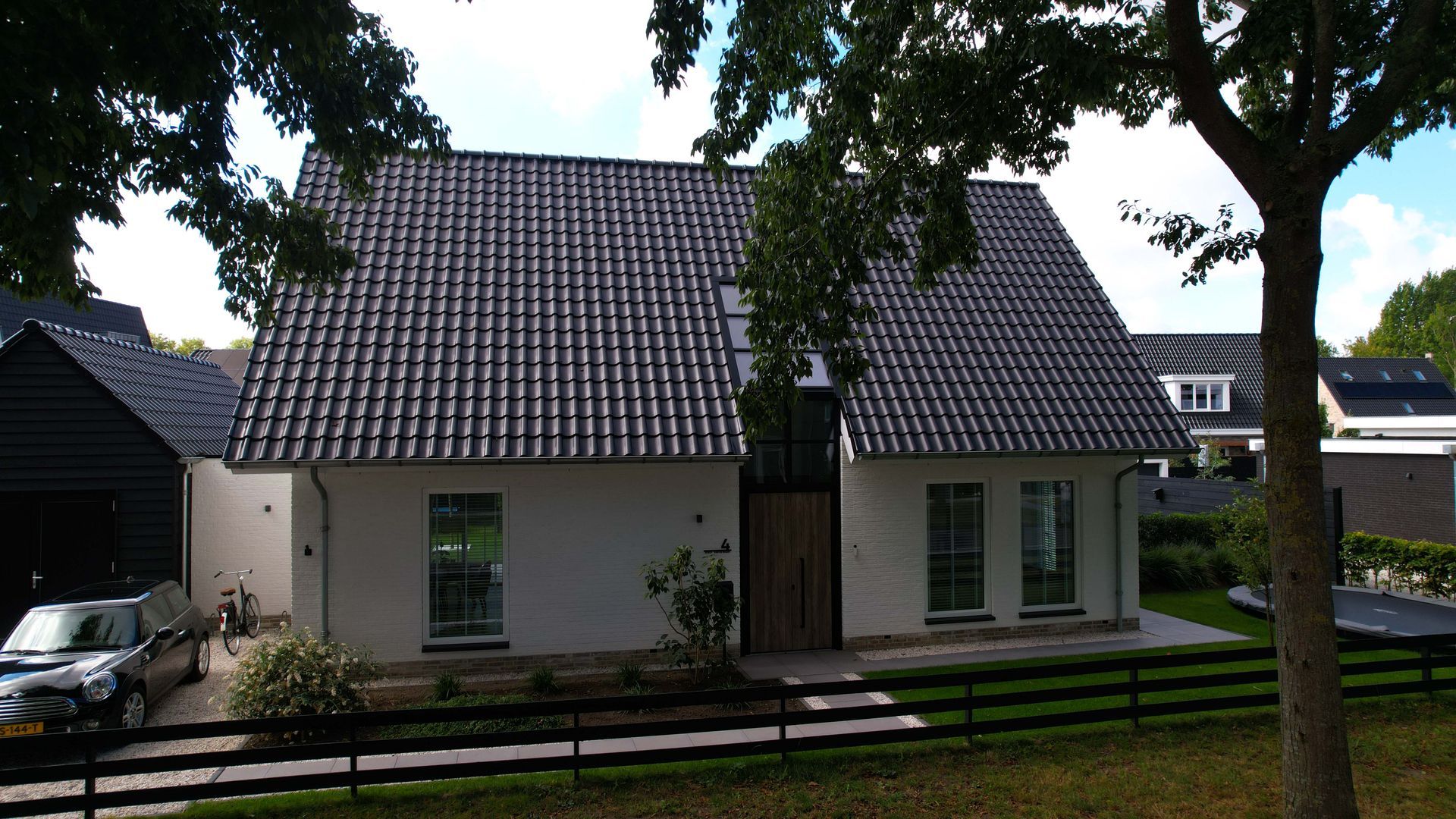 Moderne villa met landelijke invloeden. Deze stijlvolle vrijstaande woning combineert moderne architectuur met subtiele landelijke elementen. De strakke witte gevels in combinatie met het donkere zadeldak zorgen voor een eigentijdse en frisse uitstraling.