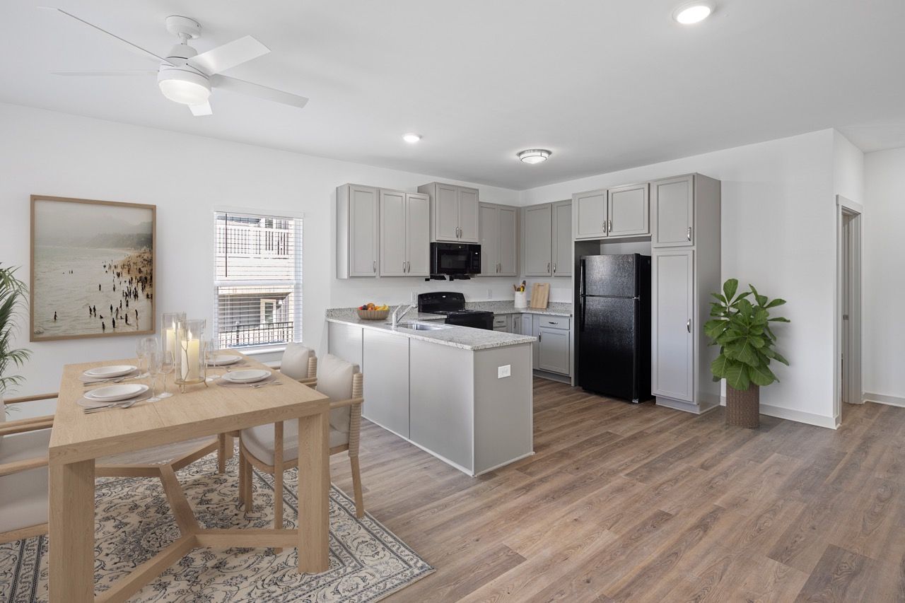 Open-concept kitchen and dining area with gray cabinets, island, stainless appliances, and wood-look flooring.