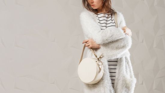 Woman with White Fur Coat and White Bag — Bayonne, NJ — Famous Furs Ltd.
