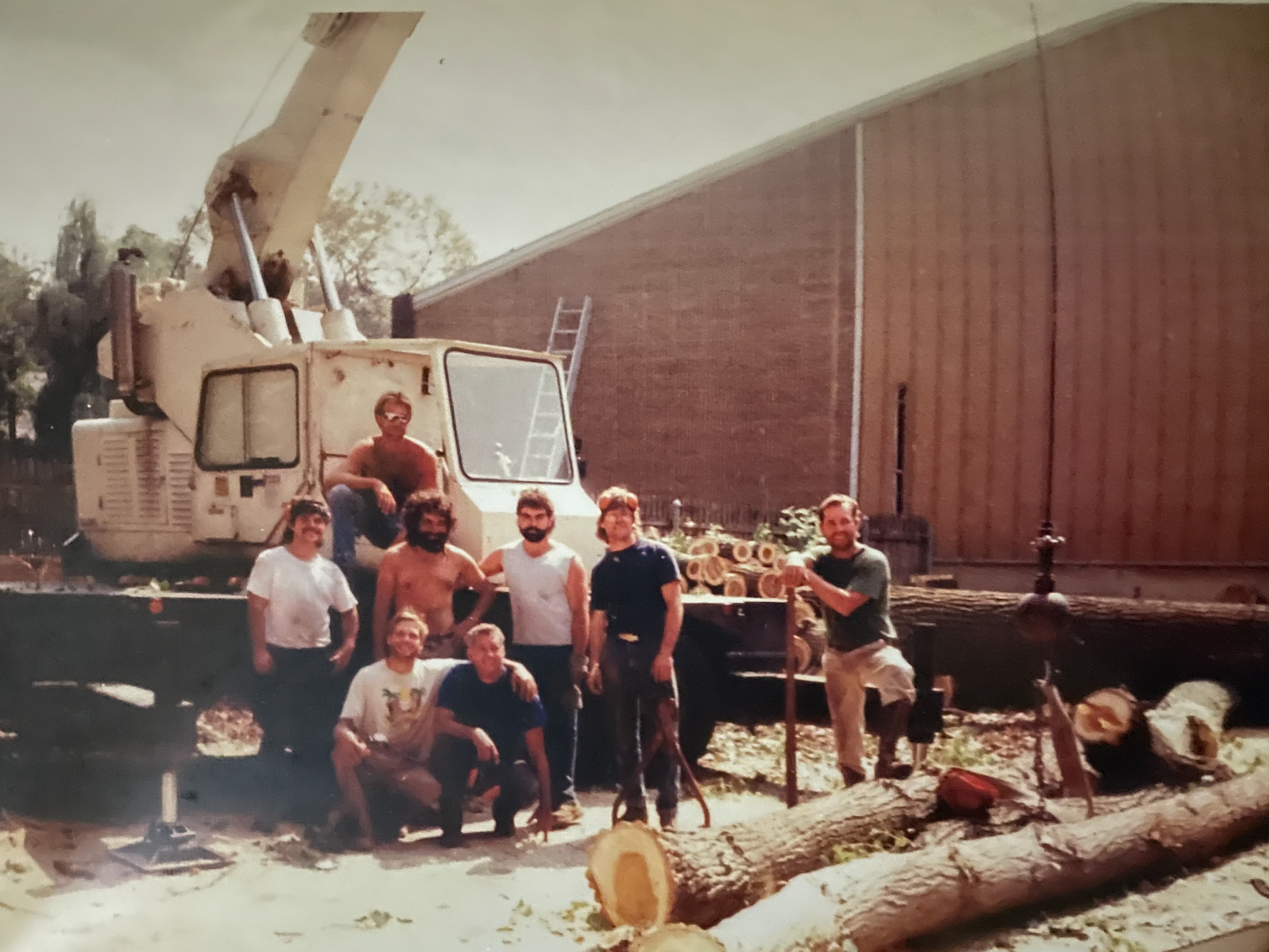 A group of people are posing for a picture in front of a crane that says ' a ' on it