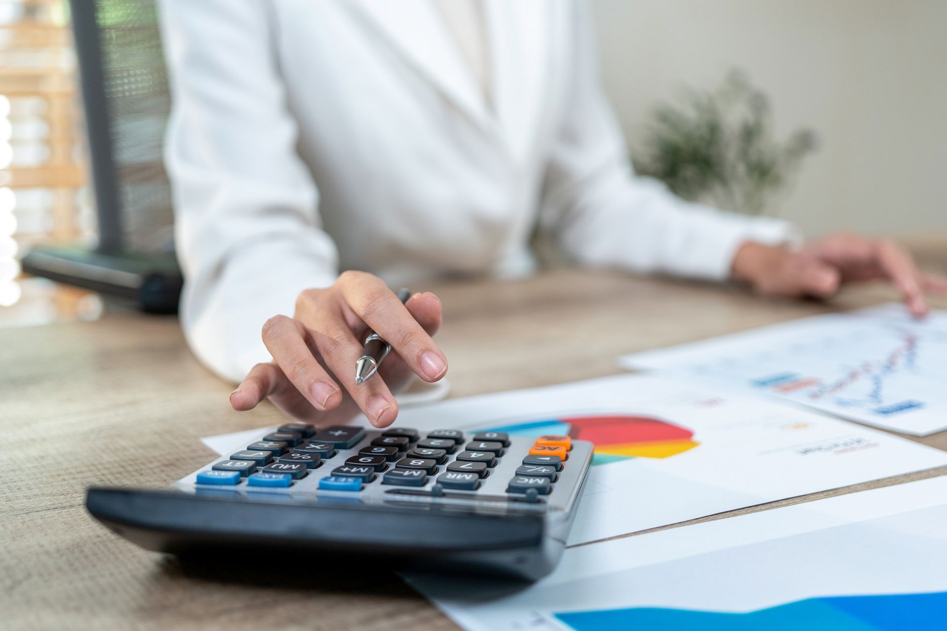 A group of people are sitting at a table using a calculator.