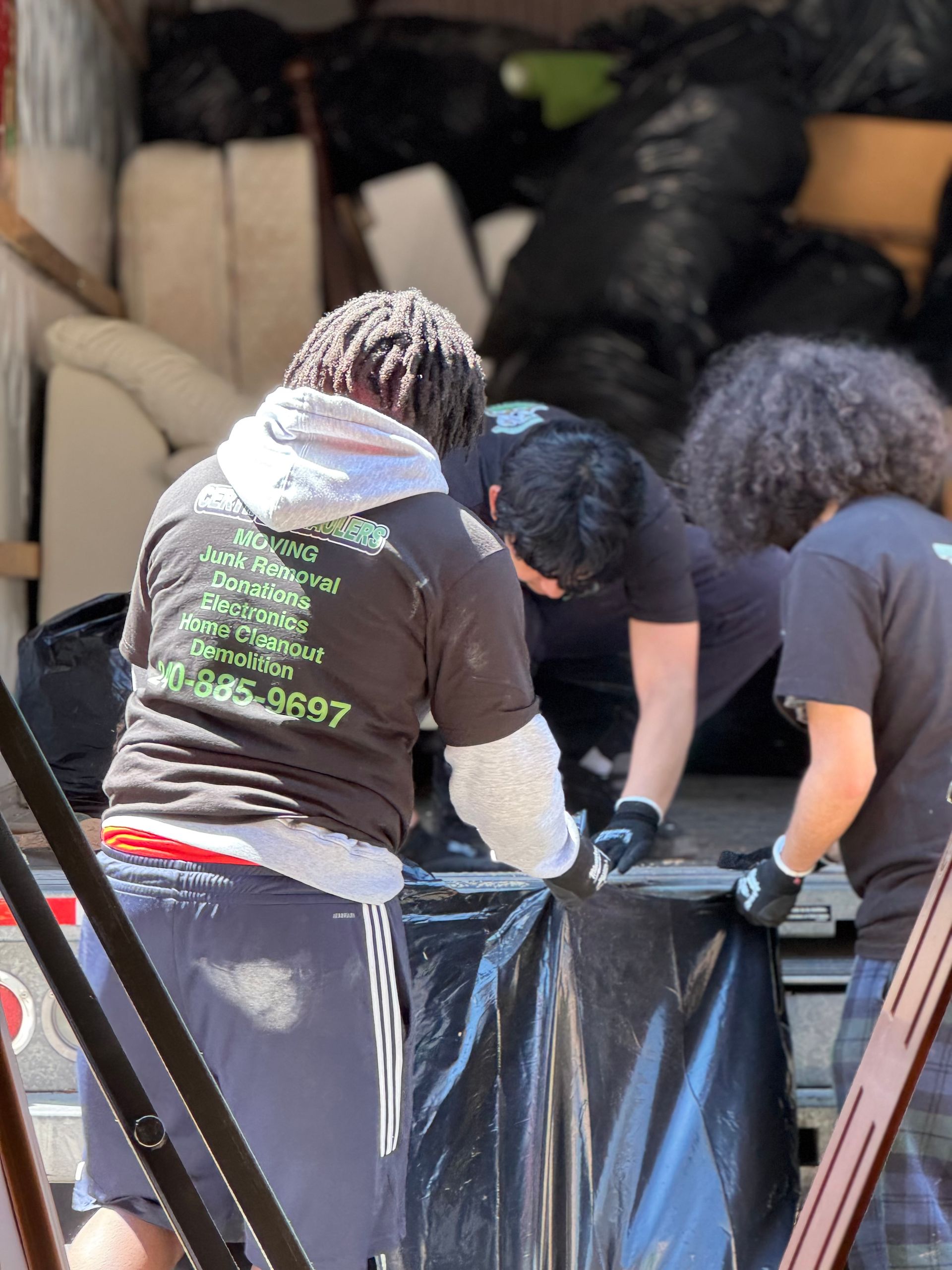Movers loading boxes into a truck with a couple observing.