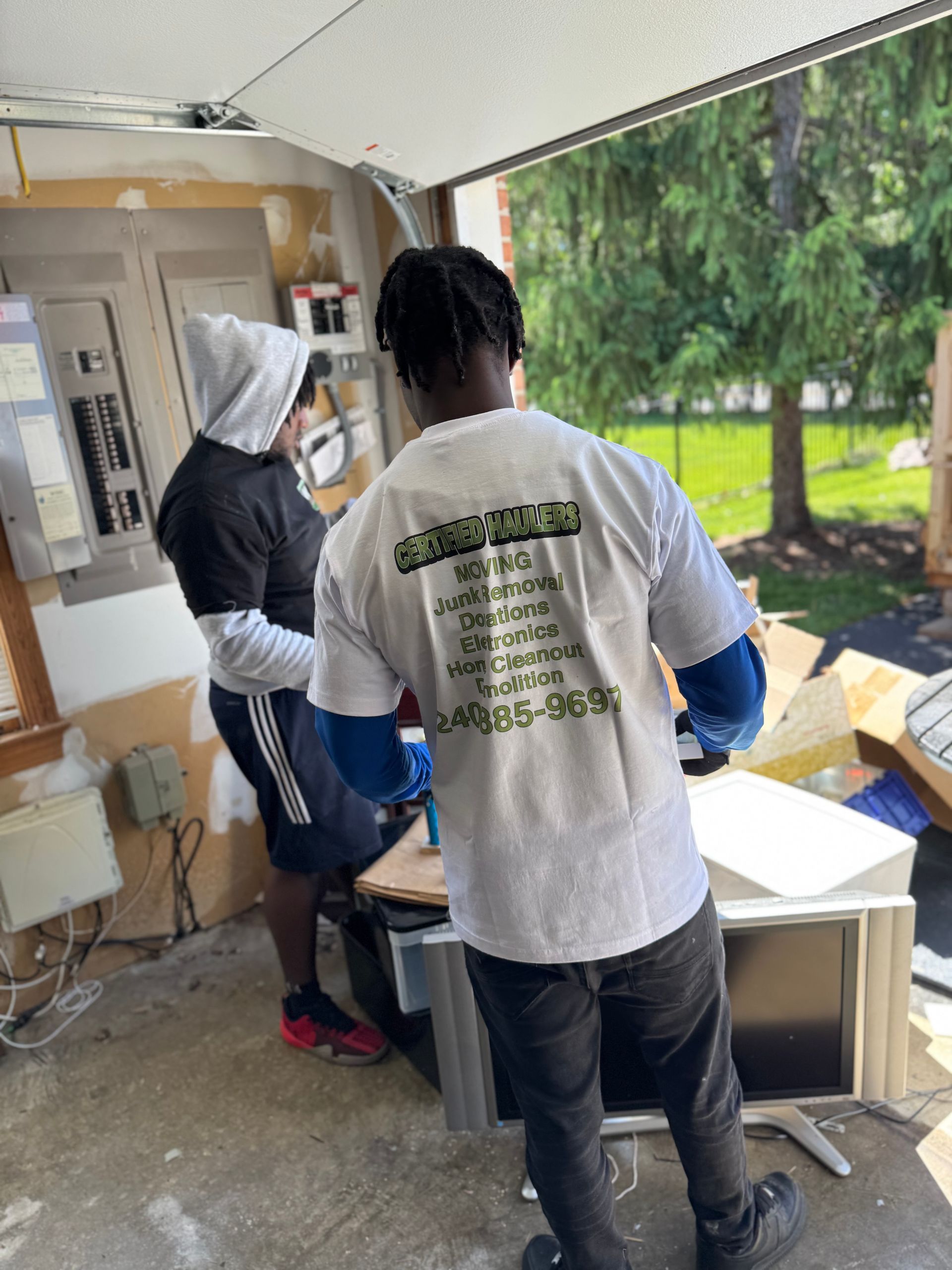 Yellow excavator loading debris into a dump truck at a construction site.