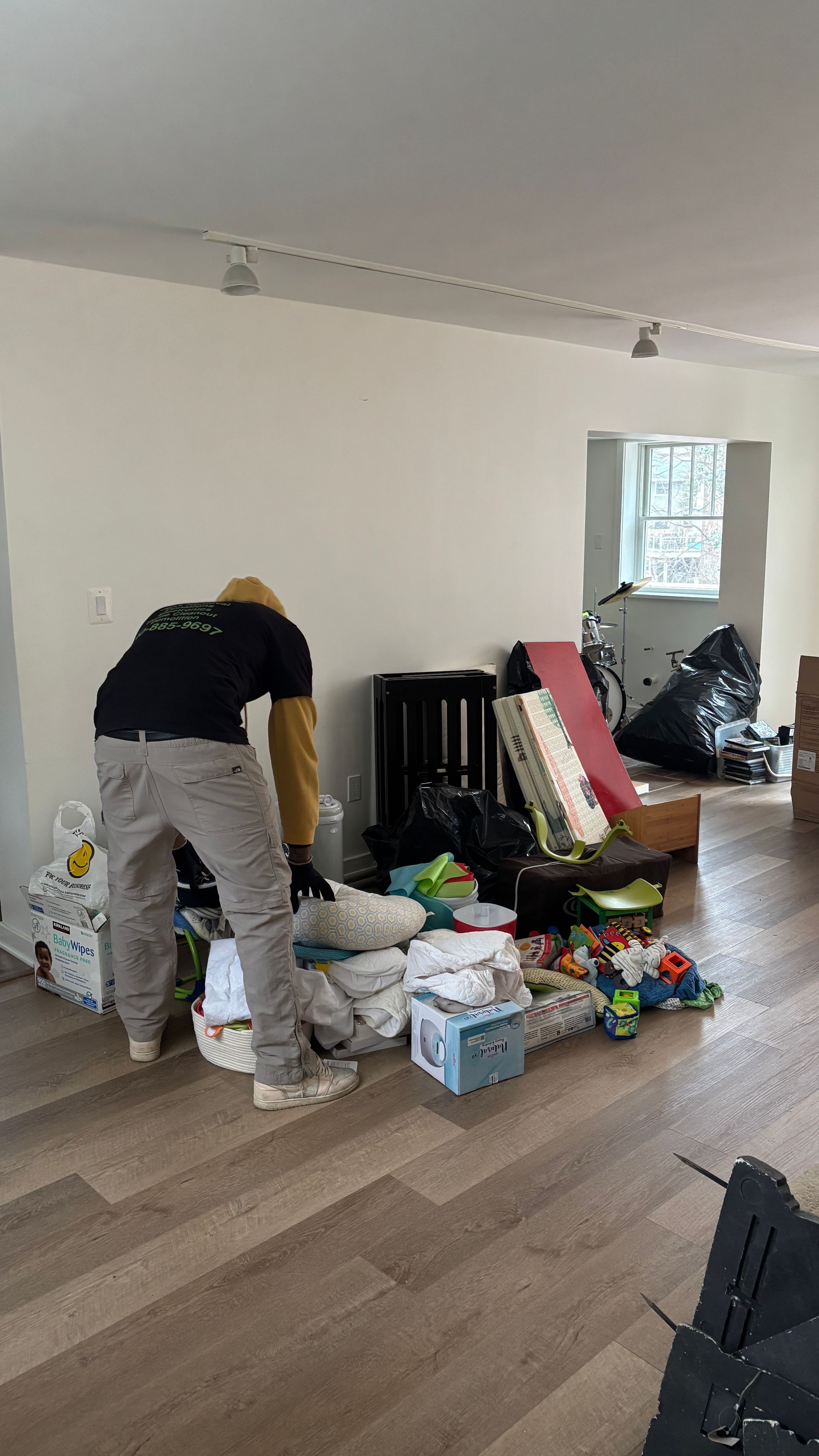 Yellow shed doors open to a cluttered interior packed with miscellaneous items, including bins, toys, and appliances.