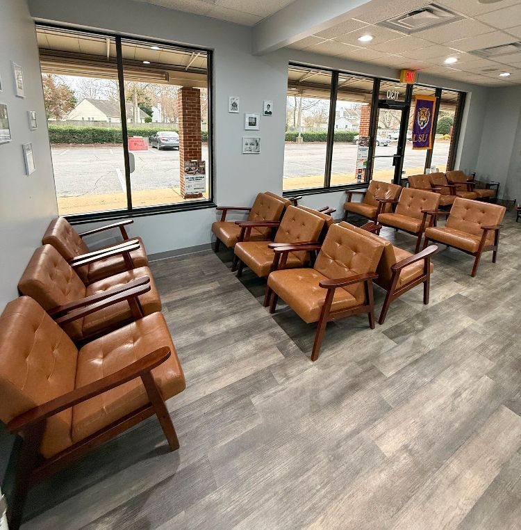 A waiting room with a lot of chairs and a window.