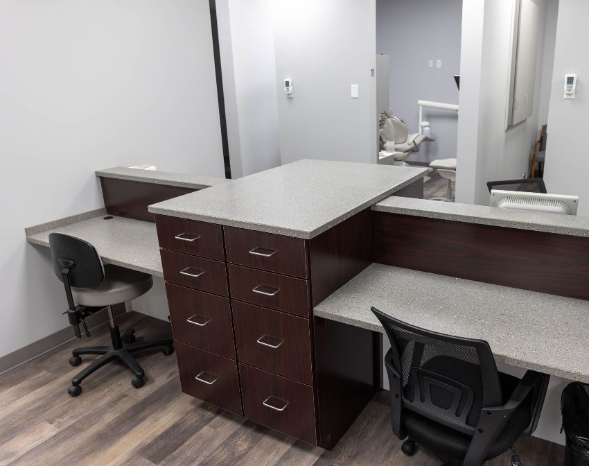 A dental office with two desks and two chairs.