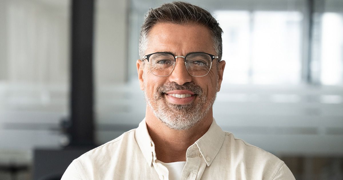 A man with glasses and a beard is smiling for the camera.