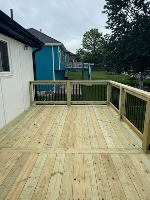 A wooden deck with a blue house in the background