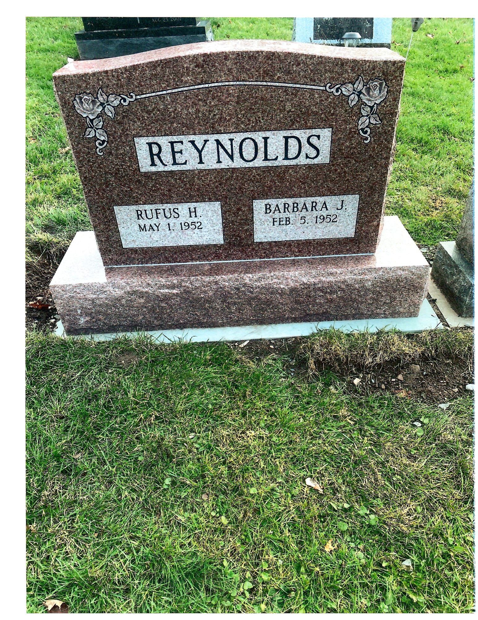 Headstone for Rufus H. and Barbara J. Reynolds, in a grassy cemetery setting.