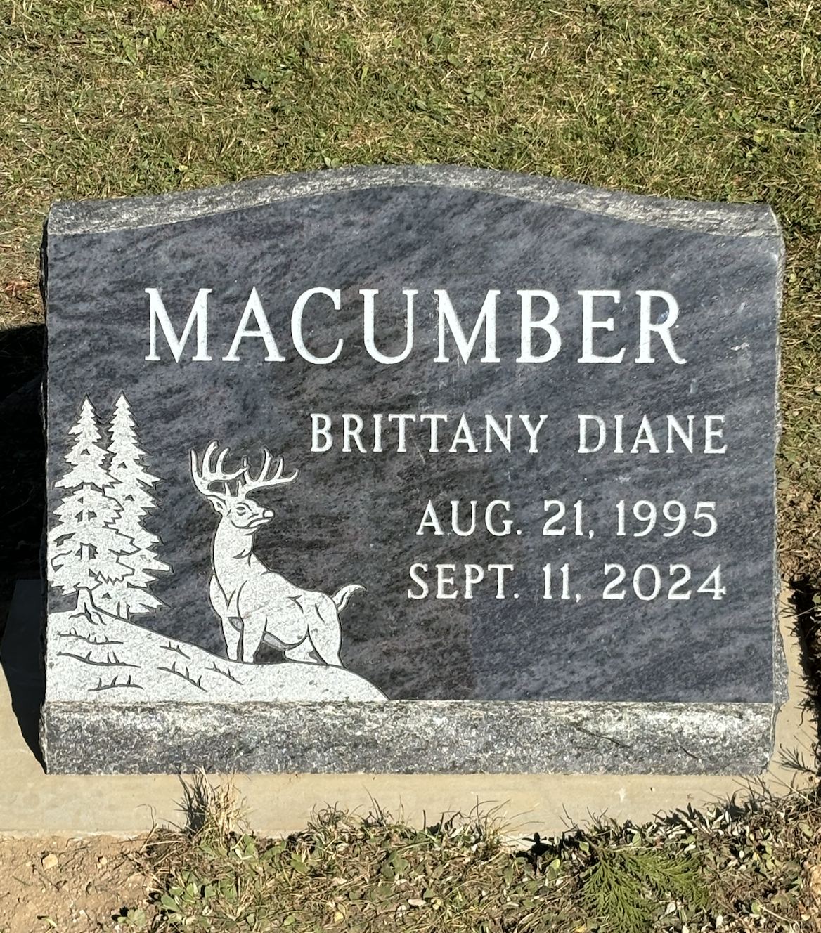 Gravestone of Brittany Diane Macumber, August 21, 1995 - September 11, 2024, with deer and tree engraving.