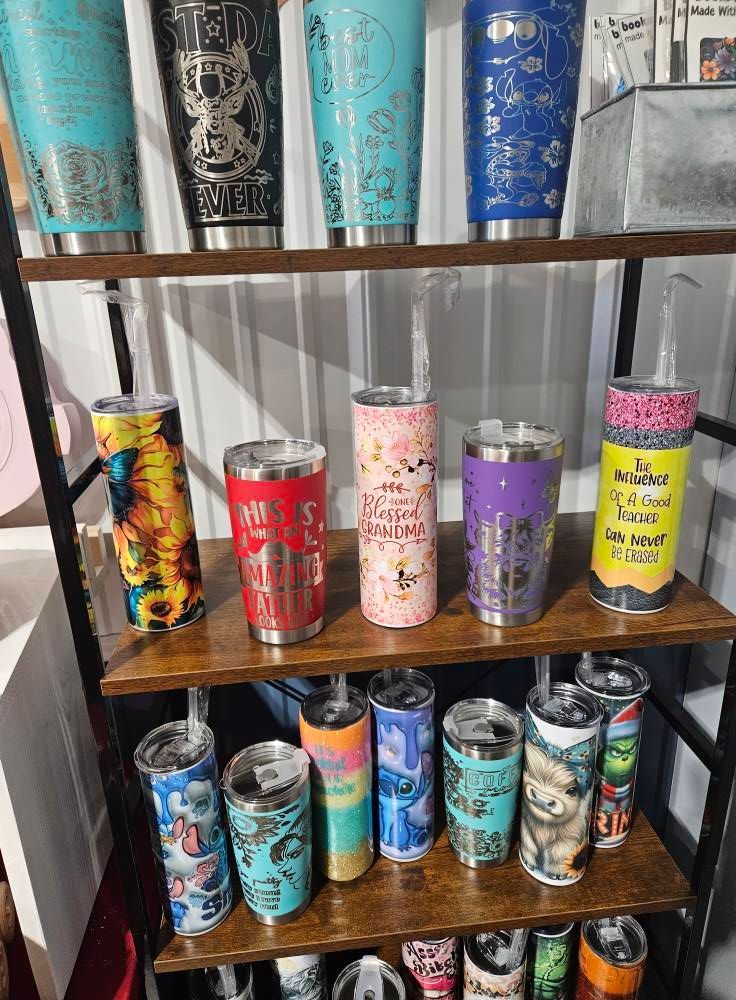 A shelf filled with a variety of stainless steel tumblers.