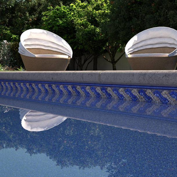Deux chaises sont posées au bord d’une piscine