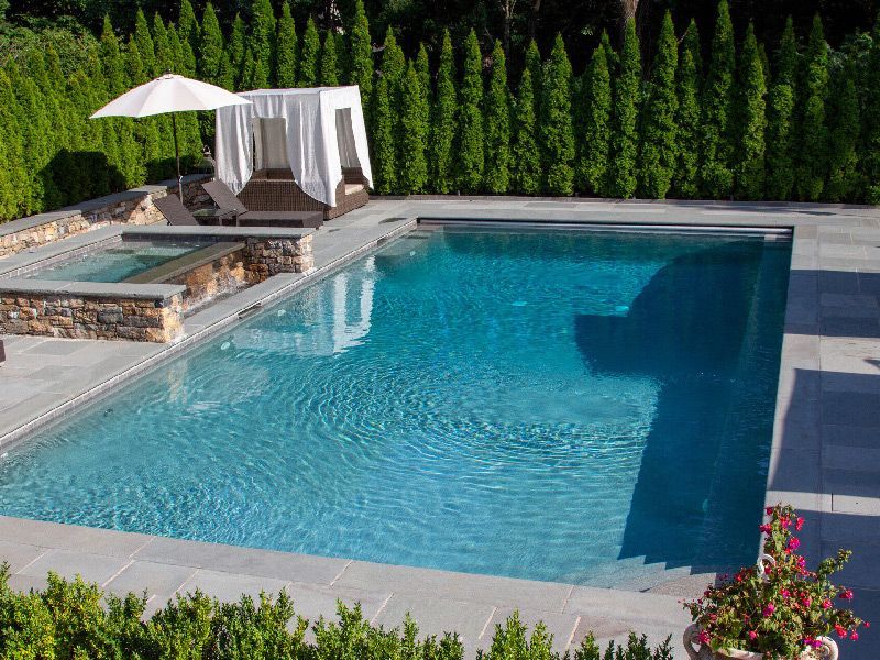 Une grande piscine avec un auvent et un parasol