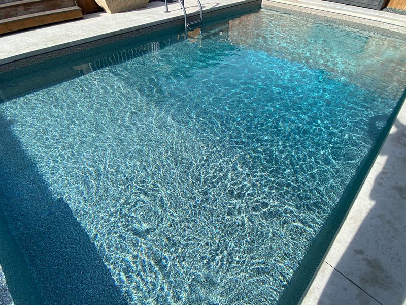 Une grande piscine remplie d'eau bleue et une échelle.