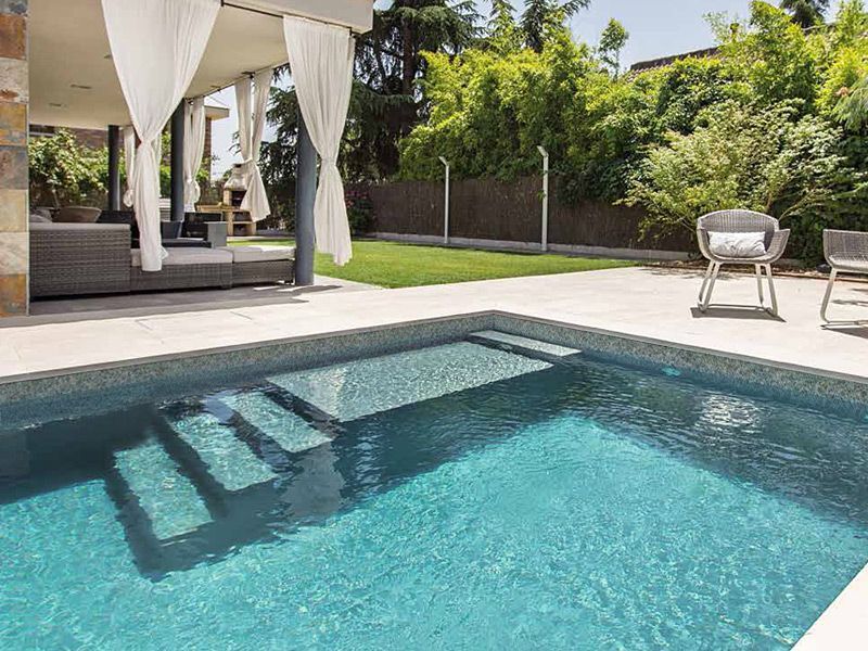 Il y a une grande piscine dans l'arrière-cour d'une maison.