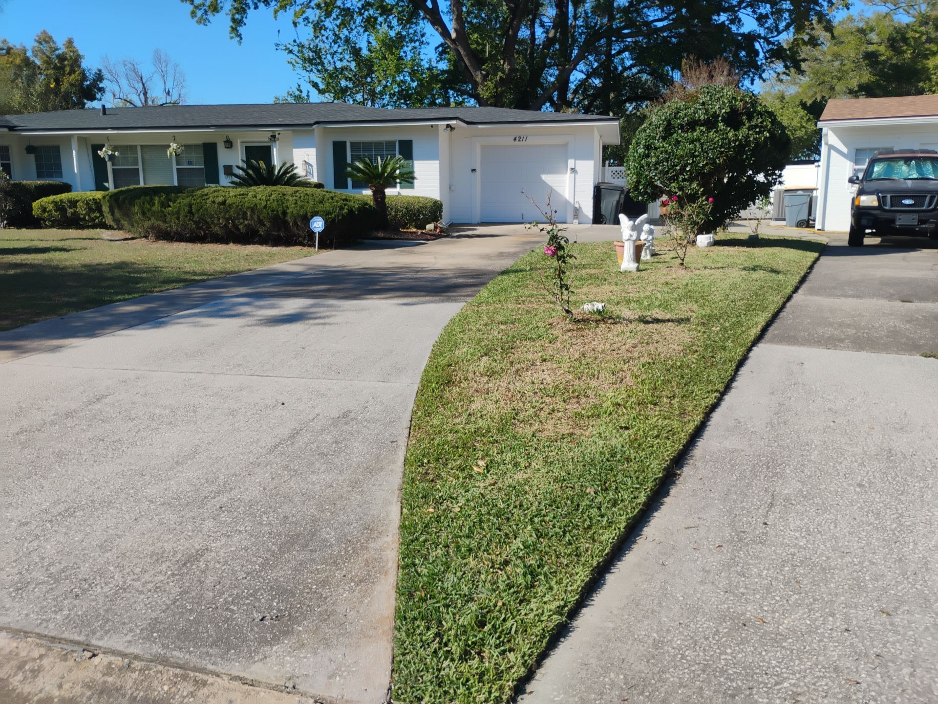 Suburban house with a driveway, lawn, and mailboxes on a sunny day