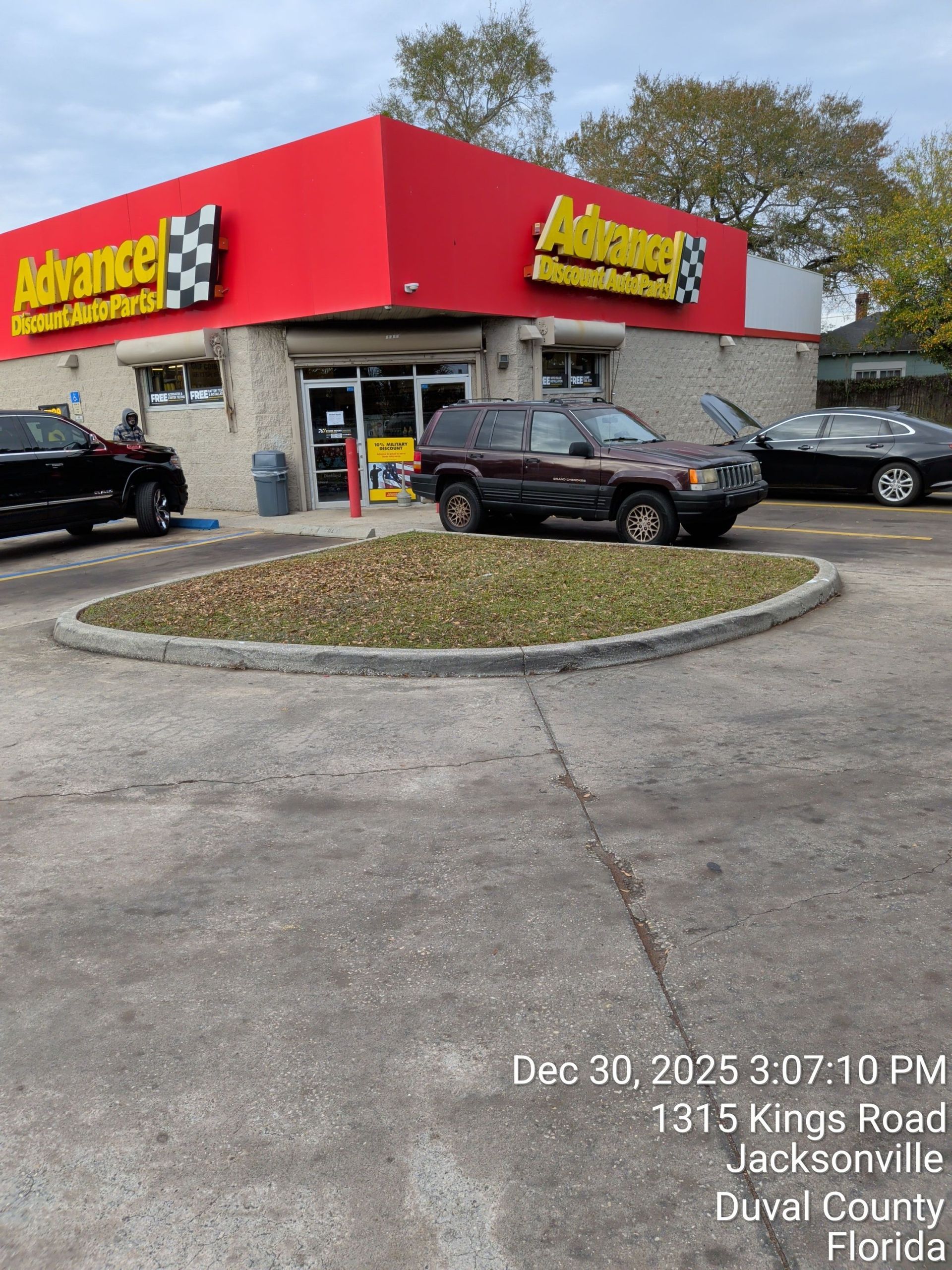 Auto repair shop with red sign and black cars in a parking lot