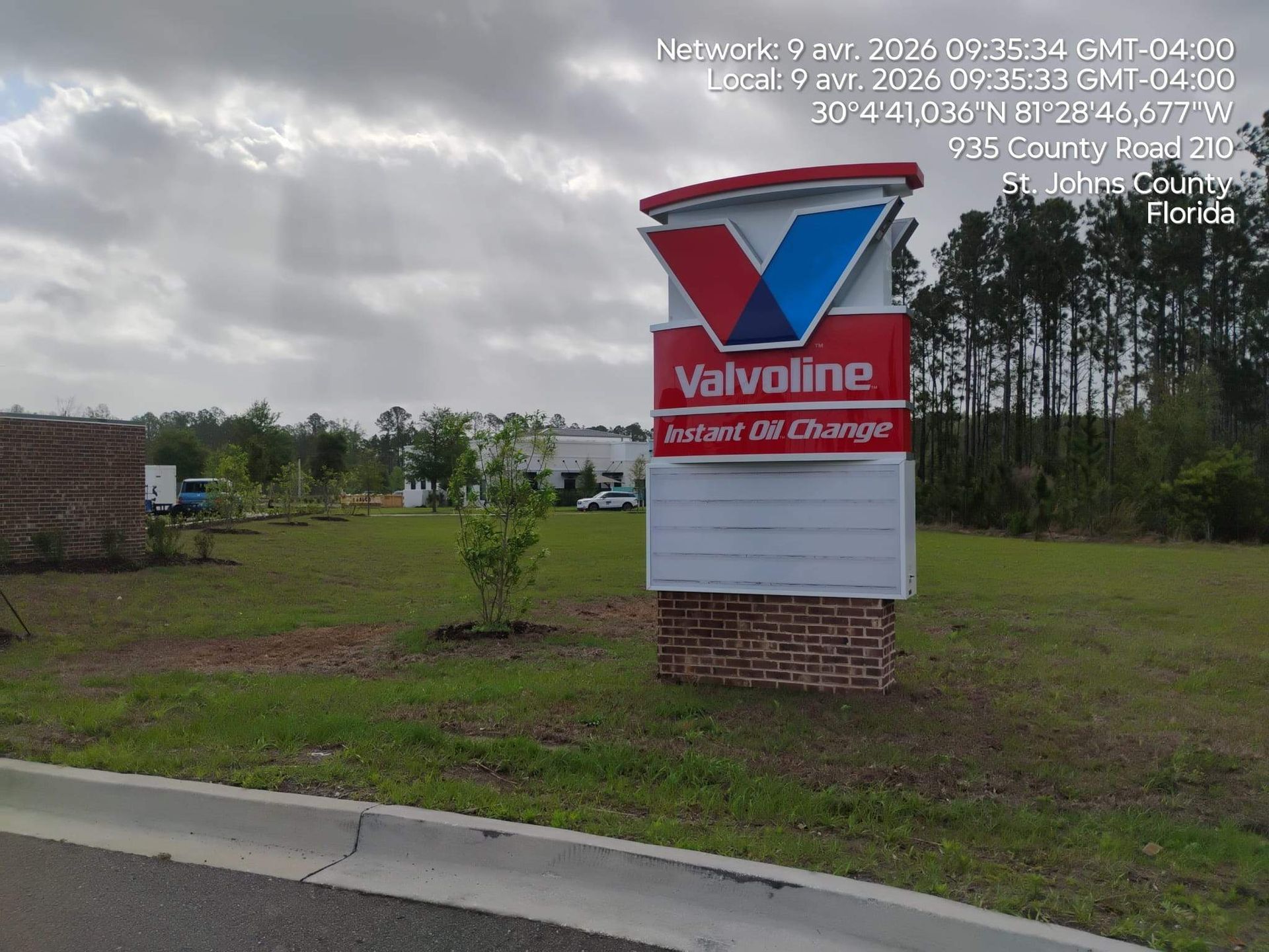 Valvoline Instant Oil Change roadside sign on a grassy lot under cloudy skies