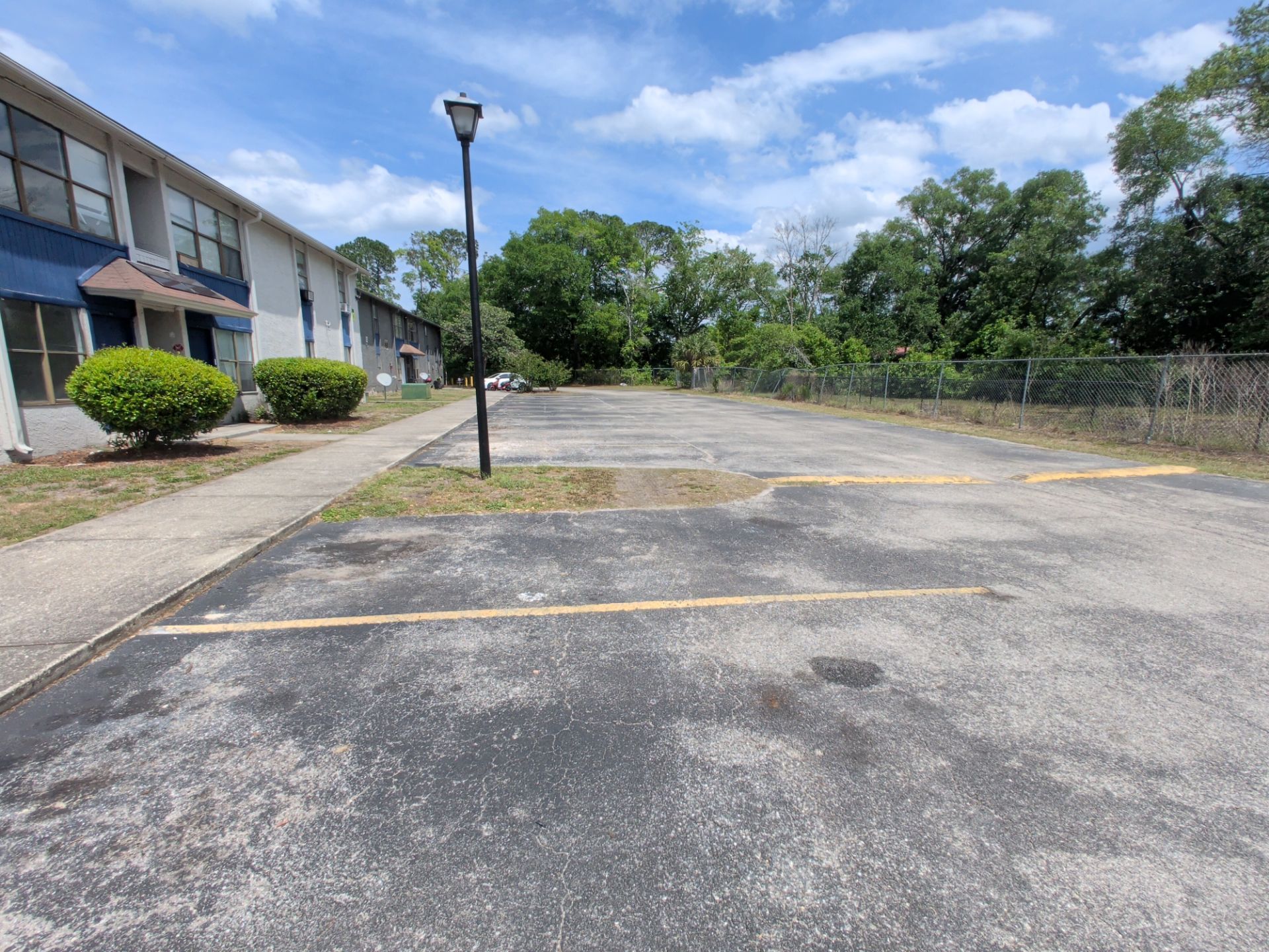 Empty parking lot beside apartment buildings on a sunny day