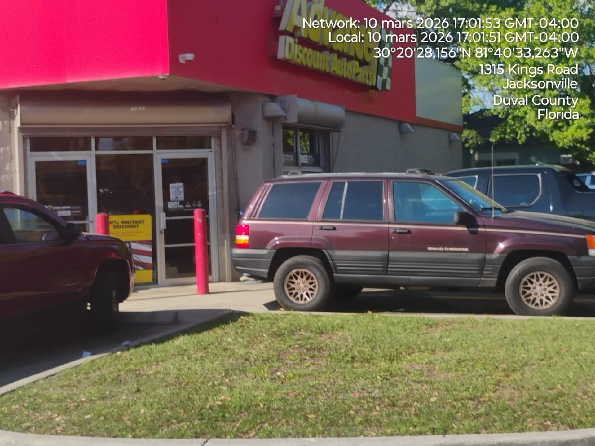 SUV parked outside a convenience store entrance under a red awning