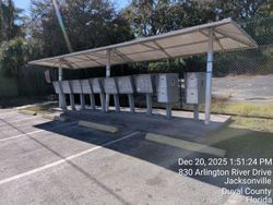 Mailboxes under a covered structure in a parking area with a timestamp showing location and date.