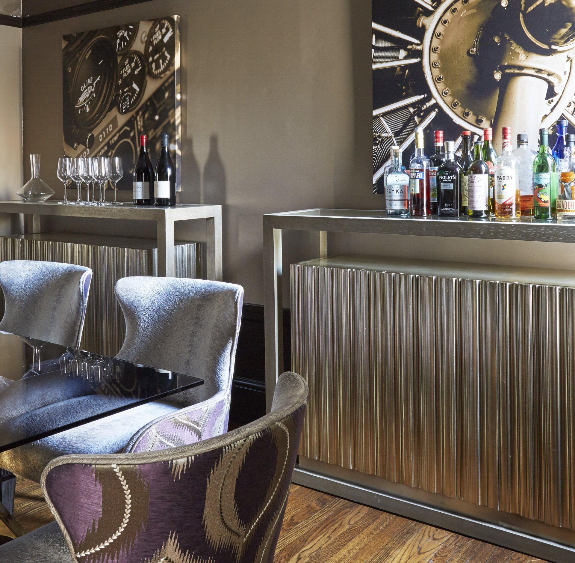 A dining room with a table and chairs and a clock on the wall