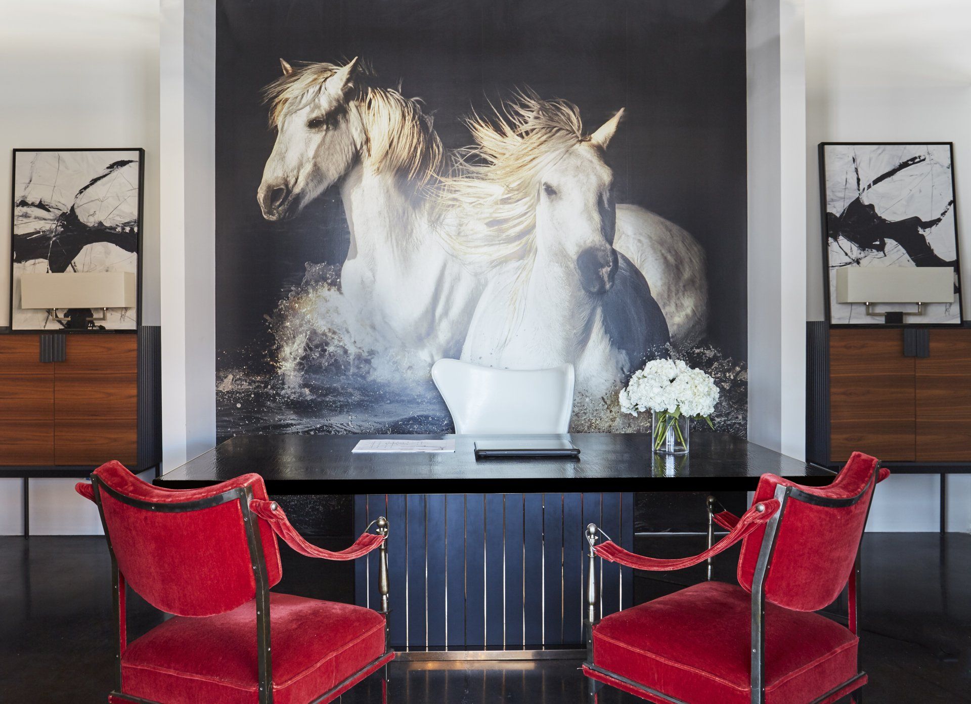 A room with a painting of two horses on the wall